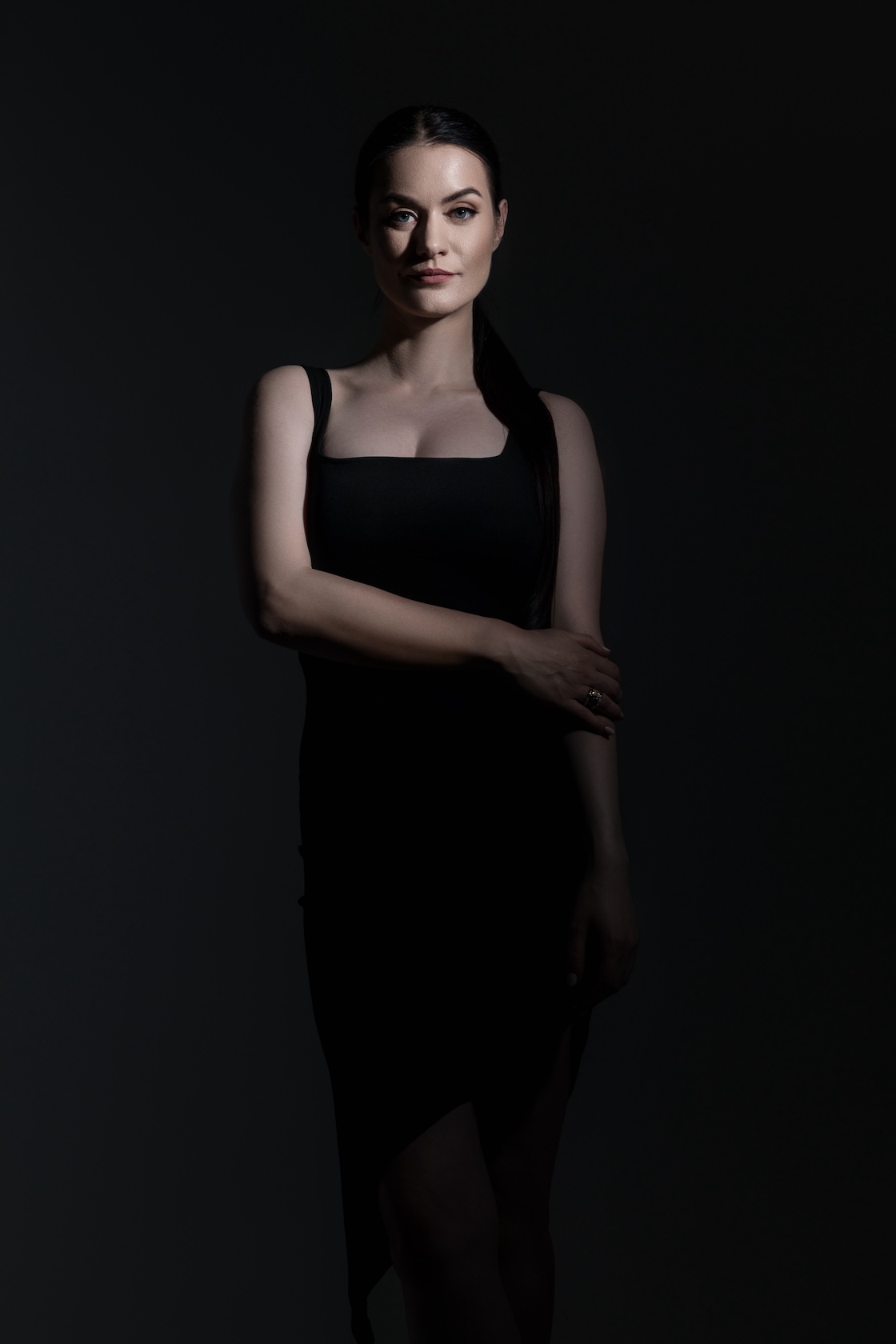 Elena Biedert in a power pose looking into camera, black background so the focus is on her face